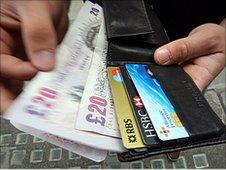 Twenty pound notes being pulled from a wallet