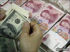 US dollar bills are counted as yuan notes are seen at a bank in Huaibei, China, file pic