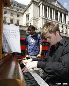 A man plays a piano outside the Bank of England