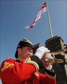 Bugler from the Royal Welsh Band plays as the Armed Forces Day flag is raised in Cardiff