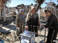 Ethnic Uzbek women vote in Osh, amid the devastation of their community