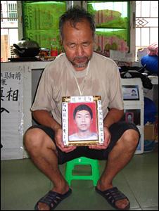 Ma Zishan holds a picture of his son