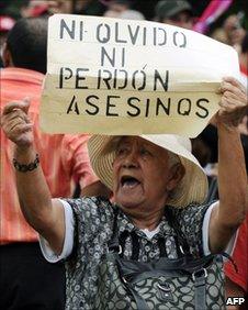 A supporter of Manuel Zelaya holds a banner reading Killers will not be forgetting or forgiven