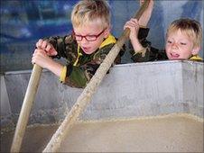 Boys stirring bowl of porridge