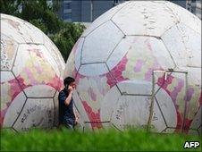 A man walks past giant footballs in Beijing