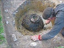 clay jar with coins in the ground