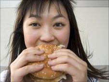 A woman eats a hamburger (file photo)