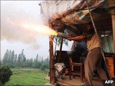 Yang Youde firing home-made cannon from his home in Yuhan, China 6 June 2010