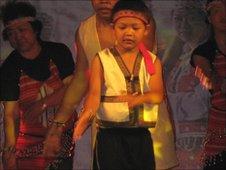 A young boy performs an indigenous dance