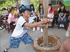 Boy pounding millet flour to make mochi