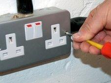 Electrician mending plug socket