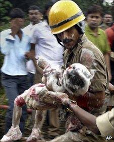 rescue worker carrying a child who survived the crash