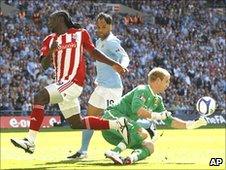 Joe Hart (right) saves from Kenwyne Jones (left)