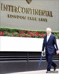 Businessman walks past the Park Lane Intercontinental Hotel in London