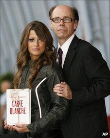 Thriller writer Jeffery Deaver (R) poses for photographers with model Chesca Miles on a BSA Spitfire motor-bike to launch the new James Bond book Carte Blanche