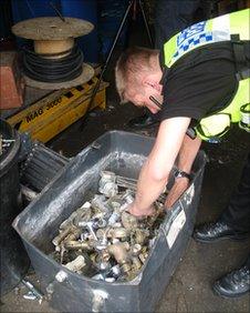 A BTP officer searches for stolen cable and metal during a scrapyard visit