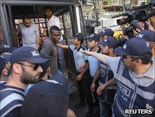 Nigerian footballer Emmanuel Emenike disembarks from a police vehicle in Turkey