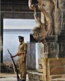 A policeman stands guard at the main entrance of the 16th-century Sree Padmanabhaswamy Temple in Trivandrum, India, Wednesday, July 6, 2011.