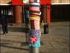 Seven short multi-coloured scarves on a lamppost