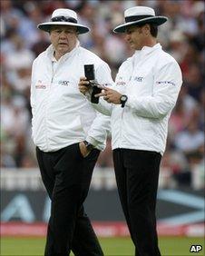 Umpires Steve Davis and Simon Taufel consult their light meters