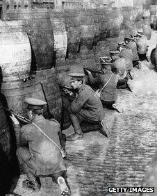 British soldiers take cover behind empty beer casks in Dublin during the Easter Rising