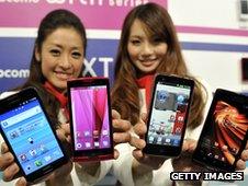 Two models hold four smartphones