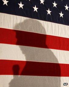 Rick Perry's shadow is cast on a flag in Boone, Iowa, on 31 December 2011