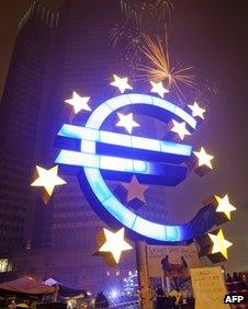 A single firework explodes above the euro sculpture in front of the European Central Bank in Frankfurt