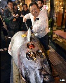 Sushi restaurant chain owner Kiyoshi Kimura poses next to a 269 kilogram blue fin tuna he purchased on the first trading day of the new year at Tokyo's Tsukiji fish market on January 5, 2012