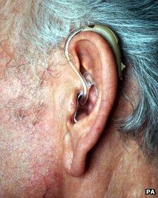 An elderly person wearing a hearing aid