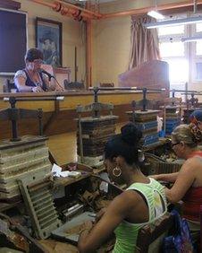 woman reads to factory workers