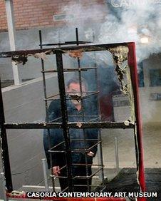 Antonio Manfredi torches a painting by French artist Severine Bourguignon in front of the Casoria Contemporary Art Museum