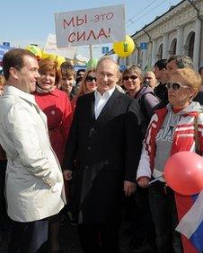 Vladimir Putin, centre, with Dmitry Medvedev and supporters at the May Day parade in Moscow