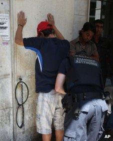 Police check suspected illegal migrants in central Athens, Sunday, Aug. 5, 2012.