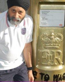 Sub postmaster Sardarah Singh next to the vandalised post box