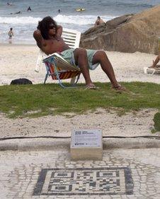 Man on beach with QR code in foreground