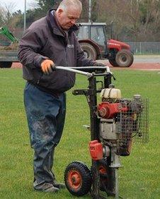 Footes Lane groundsman Shane Moon works on the pitch