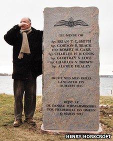 Man stands nect to the memorial