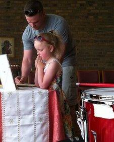 A man and a child signing a book