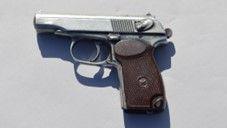A grainy picture of a small silver pistol with a brown handle.