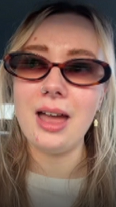 A close-up image of a woman with blonde hair and sunglasses videoing herself talking