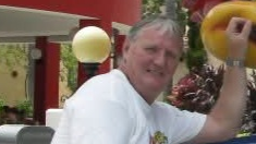 Harry Turner wearing a white top. He has grey hair. 