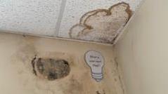 Mould and stains in the corner of a classroom