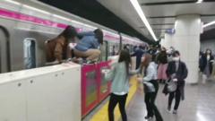 Passengers climb out of an underground train in Tokyo