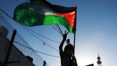 A Palestinian child gestures while holding a Palestinian flag at a protest against Israel in the Gaza Strip (2 July 2020)