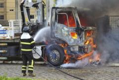 bombeiro apagando fogo em caminhão