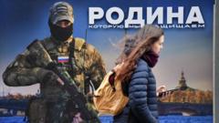 A woman walks past a stand with an image of a Russian serviceman and the inscription reading "The Motherland we defend" at a street exhibition of military-themed posters in central Saint Petersburg on February 17, 2023.