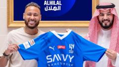 Neymar holds up an Al-Hilal shirt after signing
