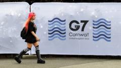 英国康沃尔郡法尔茅斯一位女士走过G7峰会场地围栏（10/6/2021）