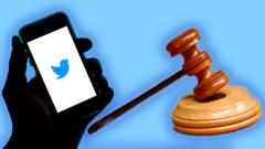 A phone with Twitter on it and a judge's mallet